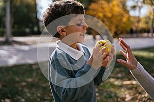 Boy eating apple near mother