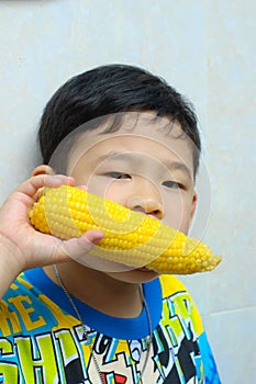 A boy eating boiled corn