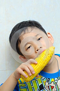 A boy eating boiled corn