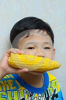 A boy eating boiled corn