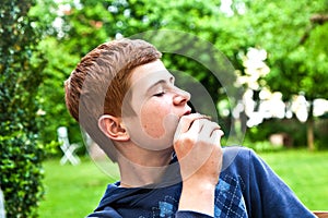 Boy eating a bread in the garden