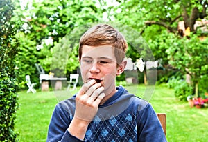 Boy eating a bread in the garden