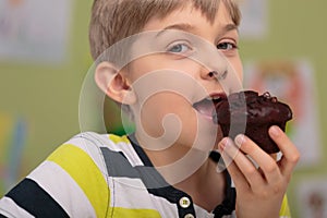 Boy eating caloric muffin