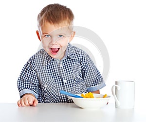 A boy is eating cereal from a bowl