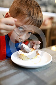 Boy eating cheesecake with sour cream