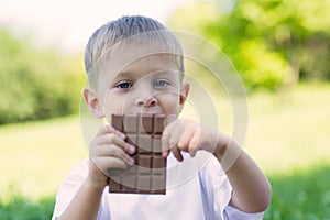 Boy is eating a chocolate bar