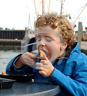 Boy eating Fish in Harbour
