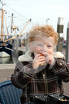 Boy eating Fish in Harbour