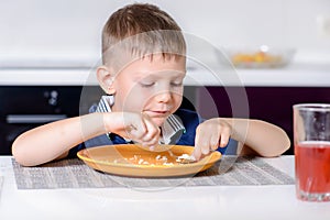 Boy Eating Last Bite of Food at Kitchen Table