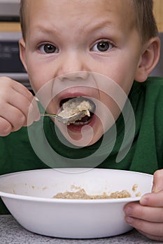 Boy eating oatmeal big bite