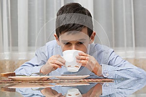 Boy eating soup at the kitchen table
