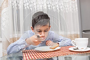 Boy eating soup at the kitchen table
