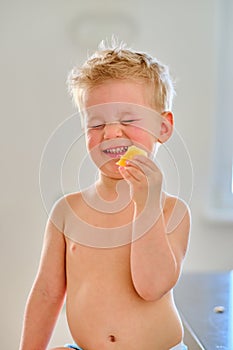 Boy eating sour fruit