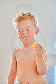 Boy eating sour fruit