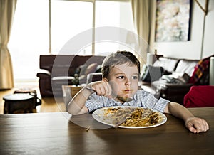 Boy eating spaghetti at home