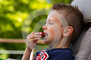 Boy eating strawberry