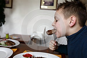 Boy eating veal lula kebab