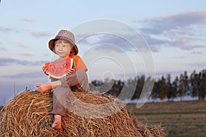 Boy eating watermelon outdoors
