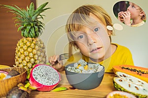 Boy eats fruit but dreams about hamburger. Harmful and healthy food for children. Child eating healthy snack. Vegetarian