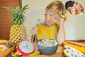 Boy eats fruit but dreams about hamburger. Harmful and healthy food for children. Child eating healthy snack. Vegetarian