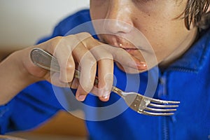 boy eats vegetable salad with a fork, covering