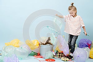 Boy eco activist sorts rubbish on blue background