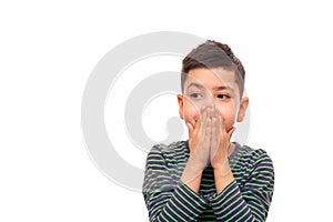 A boy  is embarrassed about something and with his palms hid his mouth restraining his emotions