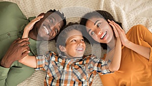 Boy Embracing Eastern Mom And Black Dad Indoor, Above View