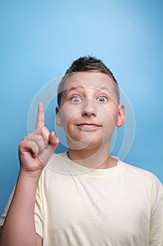 Boy with emotional face show sign of having new idea. Business idea concept. Teen Portrait on blue background