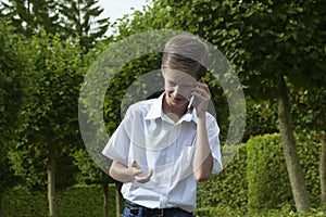 The boy emotionally speaks in the park by phone