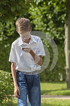 The boy emotionally speaks in the park by phone