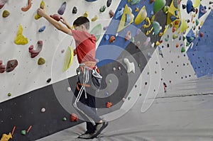 The boy is engaged in rock climbing, active recreation