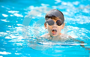 Chico feliz bien nadar en piscina 