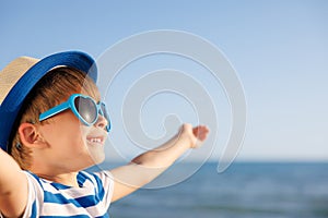 Boy enjoying by sun against sea and sky