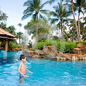 Boy enjoying a tropical swimming pool