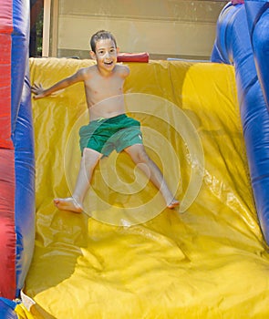 Boy enjoying a wet inflatable slide