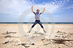 Boy enjoys the beach and jumps