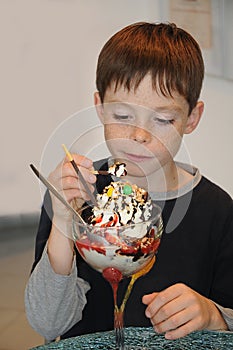 Boy enjoys ice cream in a parlor