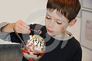 Boy enjoys ice cream in a parlor