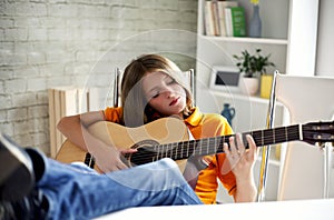 Boy enjoys playing the guitar