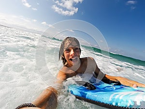 Boy enjoys riding the waves with a surfboard