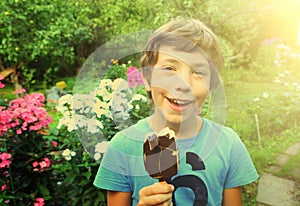 Boy with eskimo icecream in the summer garden