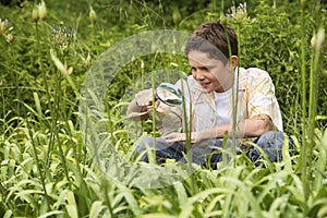 Boy Examining Plants With A Magnifying Glass