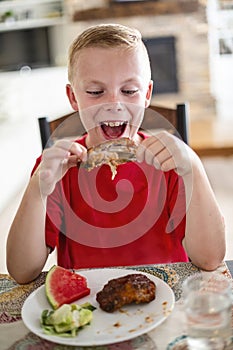 Boy excited about eating a delicious plate of Barbecue ribs