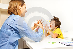 Boy exercises putting fingers with therapist