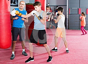 Boy exercising at boxing at gym with coach