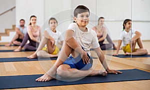Boy exercising cobra pose during family yoga training