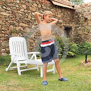 Boy exercising in front of garden lounger