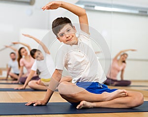 Boy exercising lotus pose during family yoga training