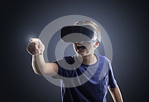 Boy experiencing using a virtual reality headset pointing
